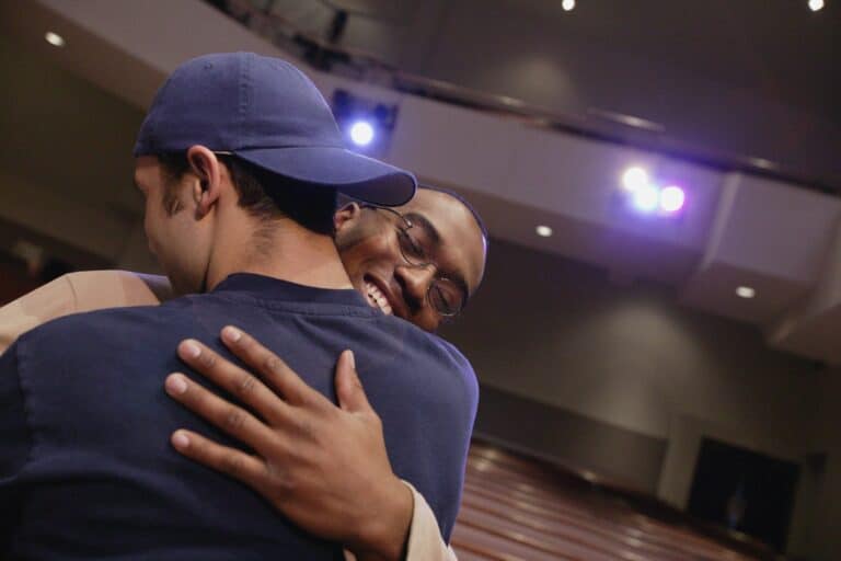 Youth ministry pastor hugging teen student at church